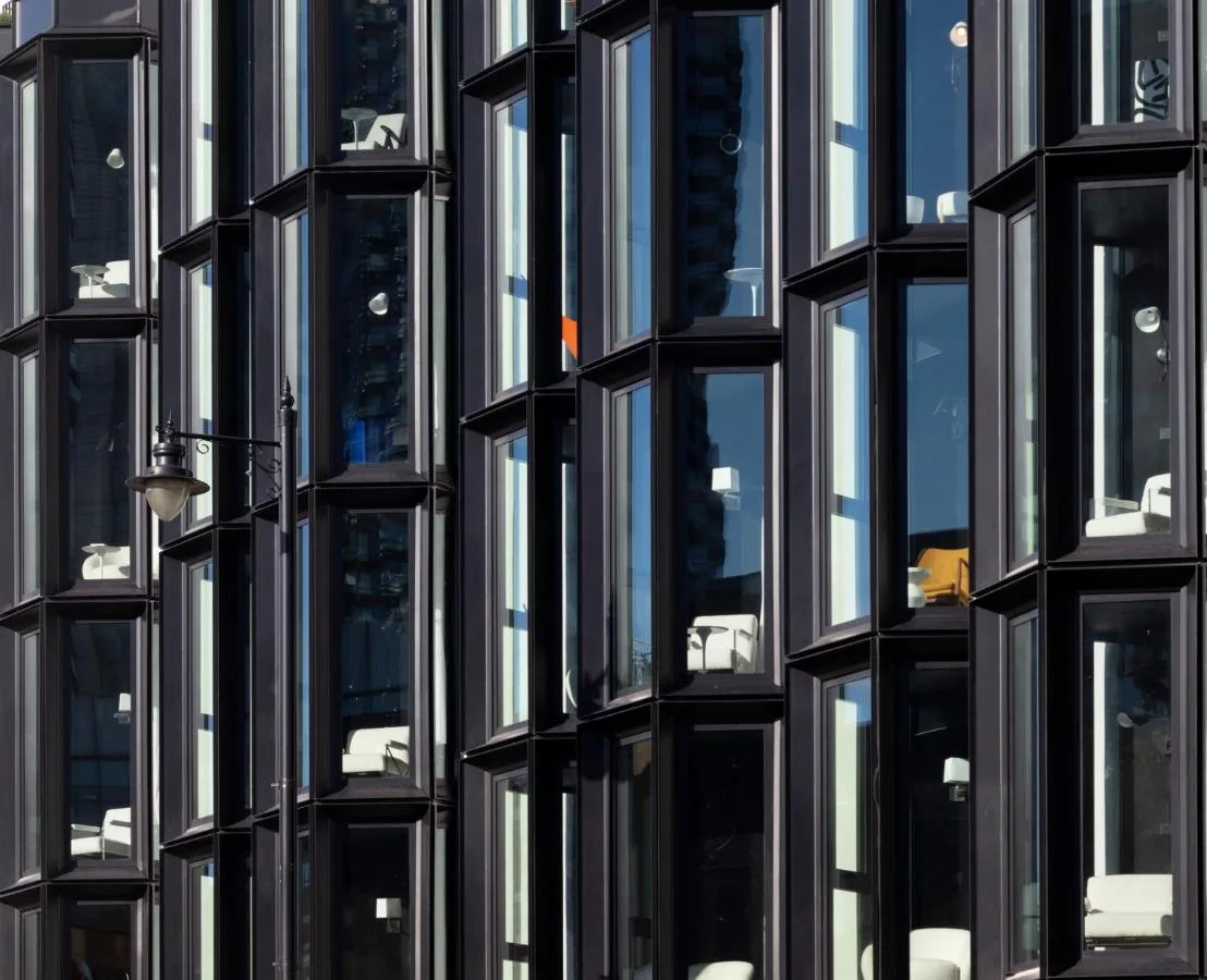 a tall black building with many windows at One Hundred Shoreditch in London